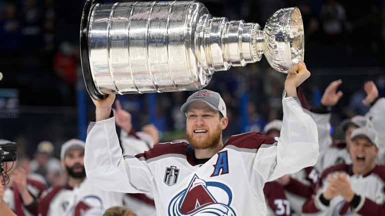 FILE - Colorado Avalanche center Nathan MacKinnon lifts the Stanley...