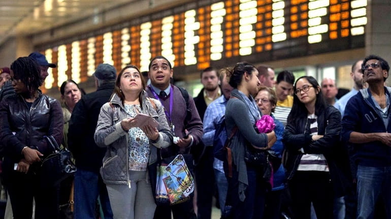 Commuters wait for their trains in Penn Station in Manhattan...