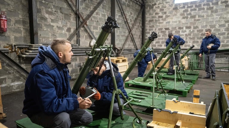 Workers check 82mm mortars at a factory in Ukraine, on...
