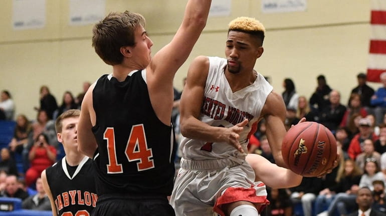 Center Moriches guard Tyiquon Nix passes the ball from under...