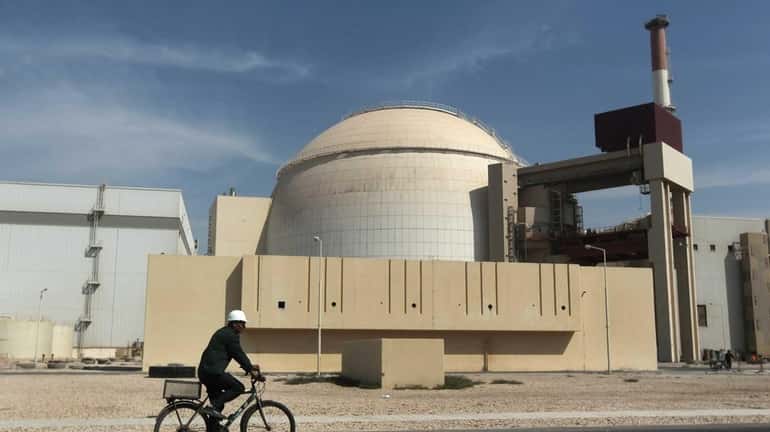 A worker rides a bicycle in front of the reactor...