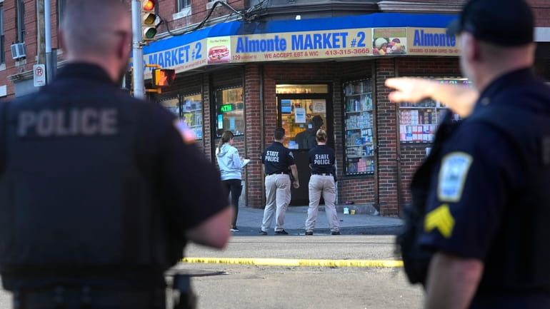 Law enforcement officials investigate the scene where multiple were shot,...