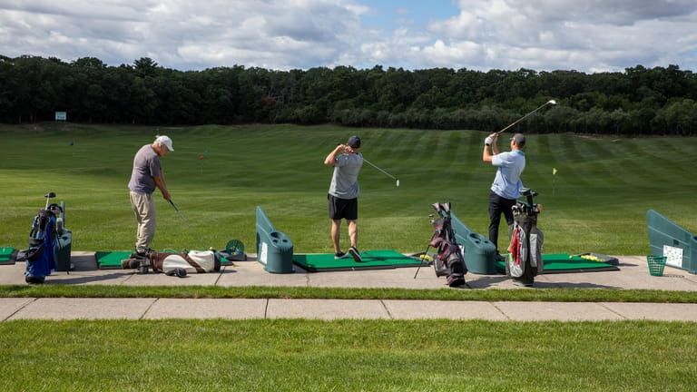 Golfers at the driving range at Mill Pond Golf Course...