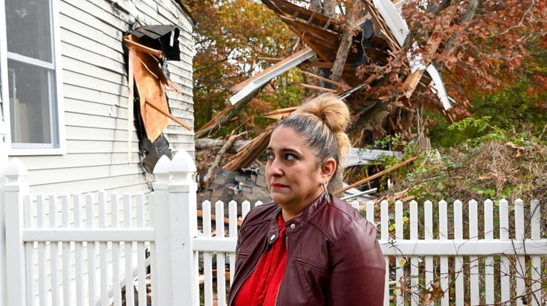 Denise Flores surveys the storm damage at her Grand Street...