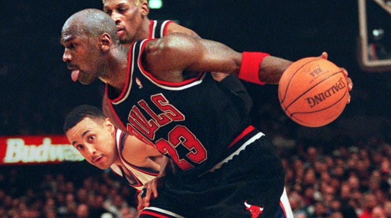 The Bulls' Michael Jordan drives past the Knicks' John Starks...