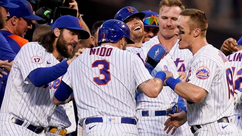 Mets catcher Tomas Nido and centerfielder Brandon Nimmo, center right, celebrate...
