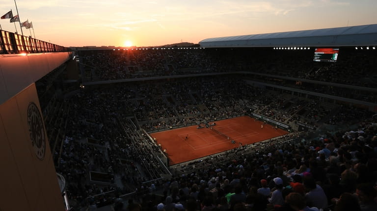 The sun sets over the court during the first round...
