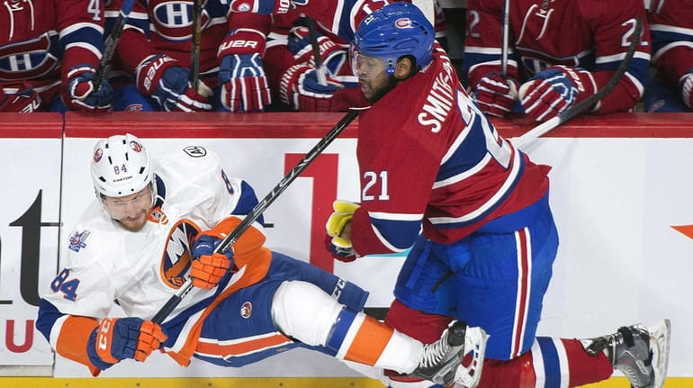 Montreal Canadiens' Devante Smith-Pelly, right, collides with New York Islanders'...