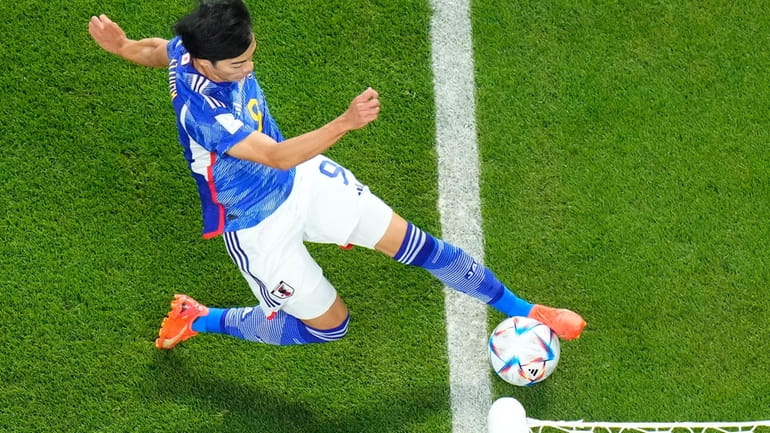 Japan's Kaoru Mitoma appears to have the ball over the...