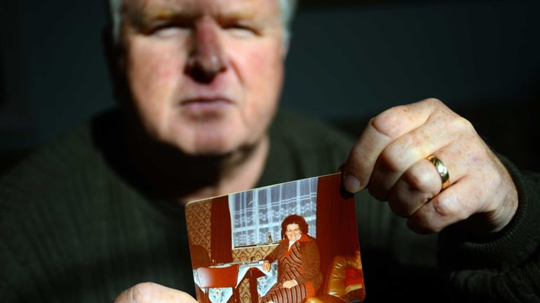 Christopher Quirin holds a photo of his mother, Margaret Murphy,...