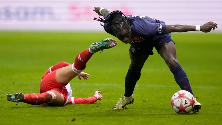 PSG's Tabitha Chawinga, right, challenges for the ball with Bayern's...