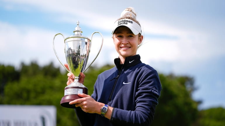 Nelly Korda holds up the trophy after winning during the...