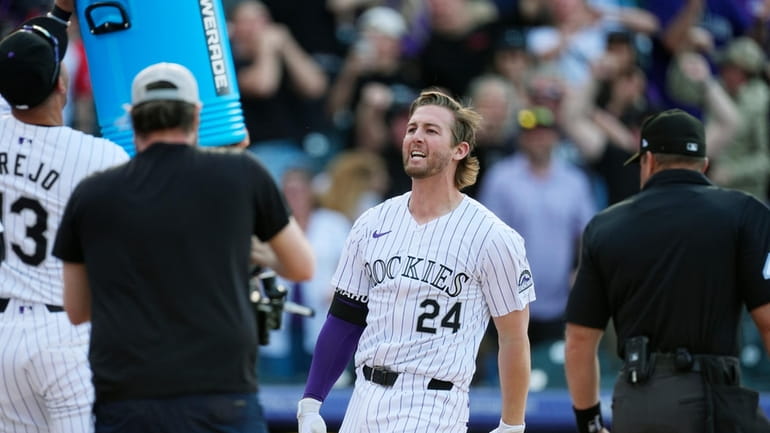 Colorado Rockies' Ryan McMahon arrives at the plate after hitting...