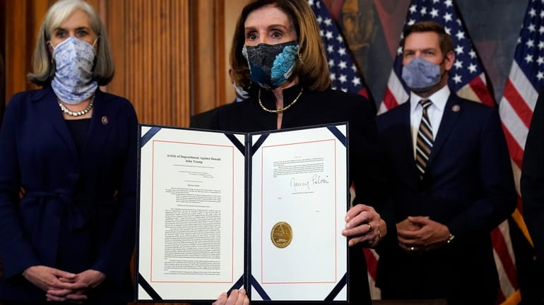 Speaker Nancy Pelosi with the document she signed Wednesday after...