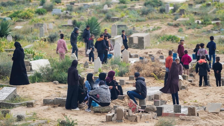 Palestinians visit the graves of their relatives who were killed...