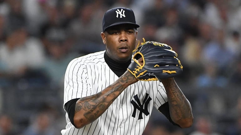 Yankees relief pitcher Aroldis Chapman looks at first base during the...