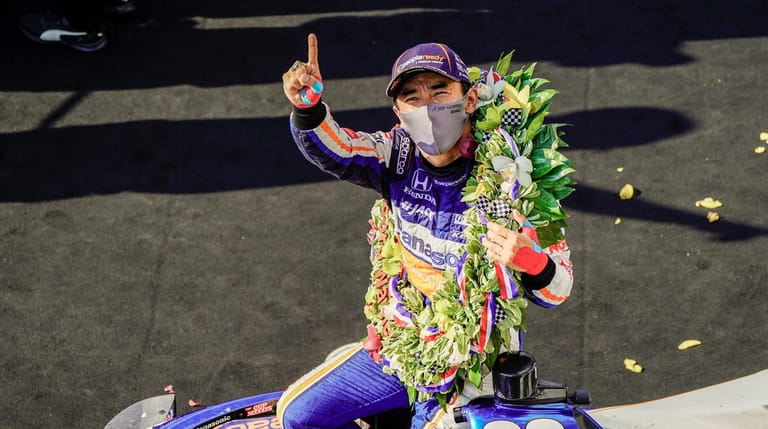 Takuma Sato of Japan celebrates after winning the 104th running...