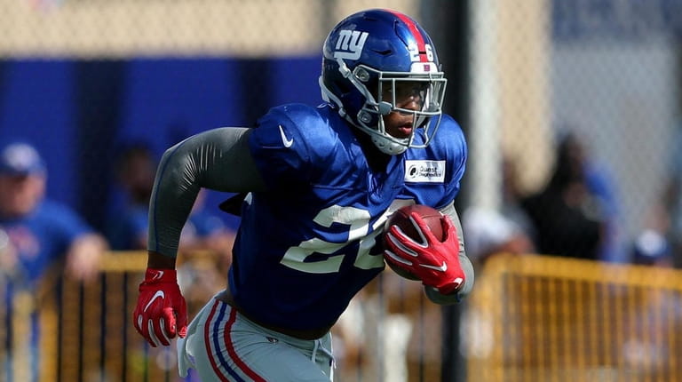 Saquon Barkley carries the ball during Giants training camp at...