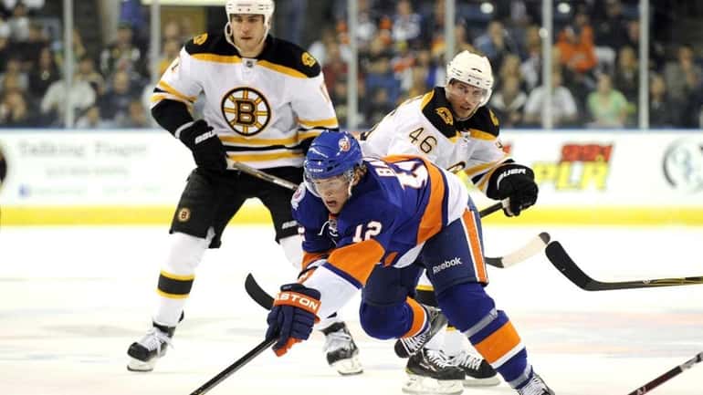 New York Islanders' Josh Bailey, center, stretches for the puck...