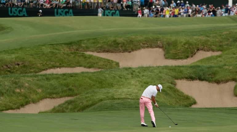 Justin Thomas hits to the 18th green during the third...