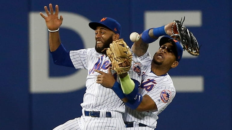 Amed Rosario and Dominic Smith of the Mets collide and...