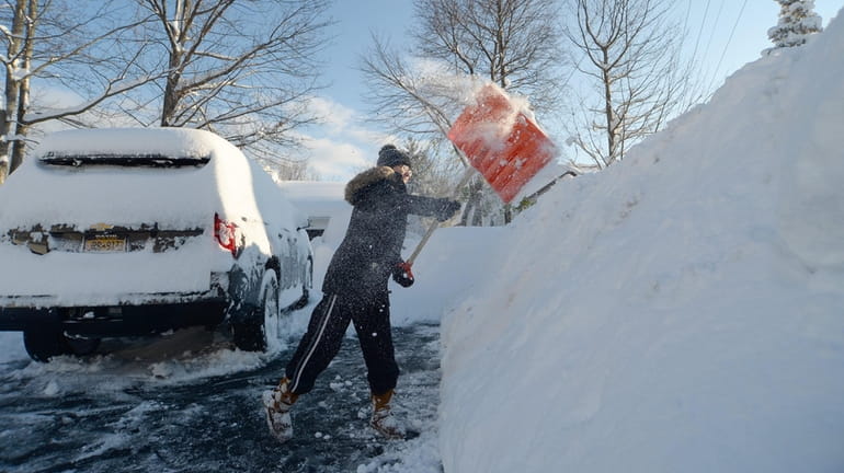 Heather Ahmed digs out on Saturday after an intense lake-effect...