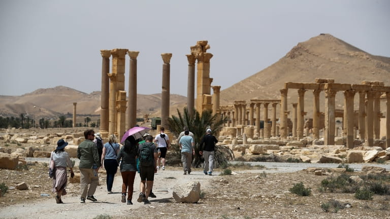 Tourists visit Roman ruins in Palmyra, Syria, Tuesday, May 11,...