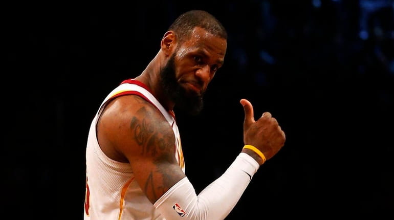 LeBron James of the Cavaliers reacts after hitting a three-point...