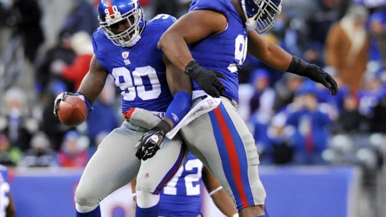 Jason Pierre-Paul, left, and Barry Cofield celebrate Pierre-Paul's fumble recovery...