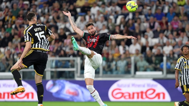 AC Milan's Olivier Giroud reaches for the ball for the...