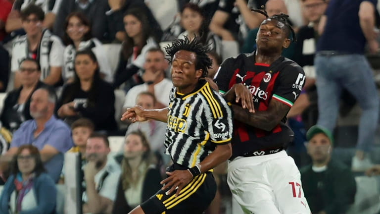 Juventus' Juan Cuadrado, left, and AC Milan's Rafael Leao, right,...
