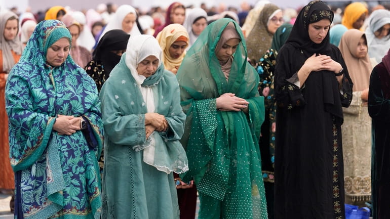 American Muslims women pray to mark the end of the...