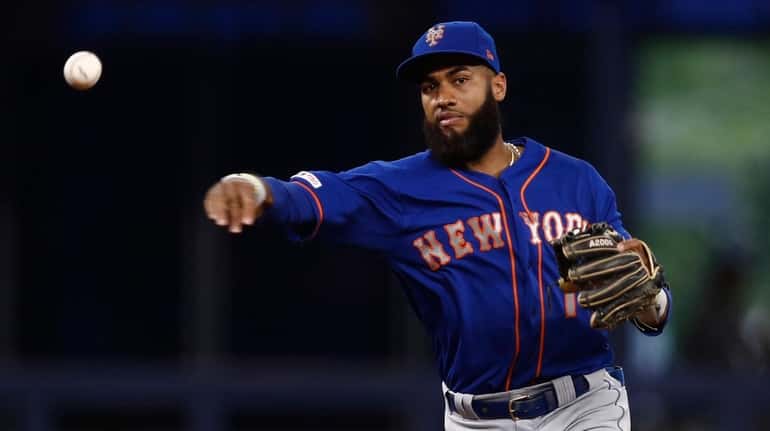 Mets shortstop Amed Rosario throws to first base during the...