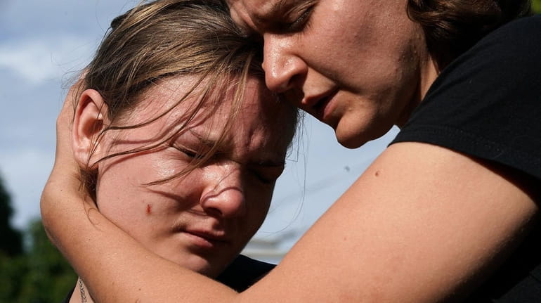 Jessica Mink, right, embraces Nicole Jones during a vigil on...