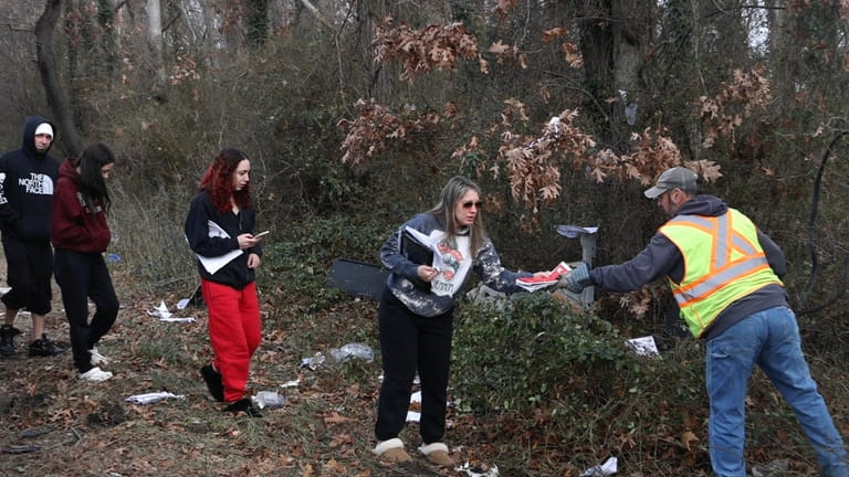 Adriana Barrington, third from left, collects belongings of crash victims...