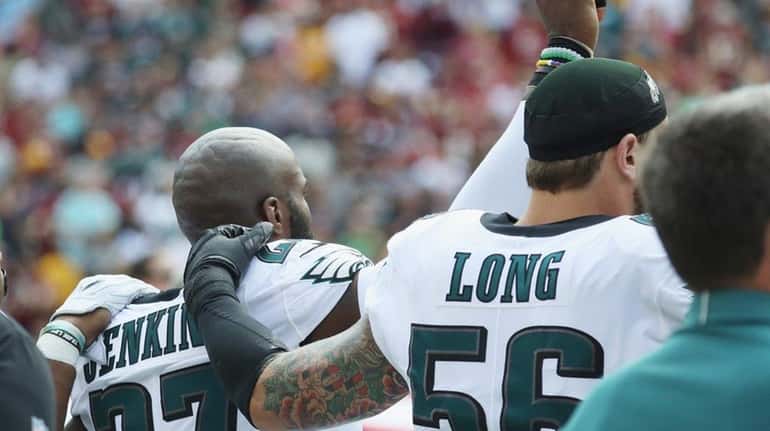 Eagles' Malcolm Jenkins and Chris Long react during the national...