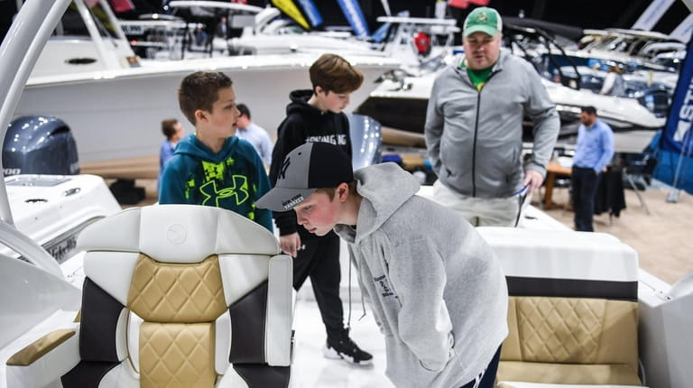 Rowan Grawehr checks out a boat with his brothers Quin and...