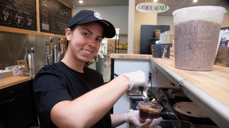 Angelina Perry prepares a frozen acai bowl at her newly opened...