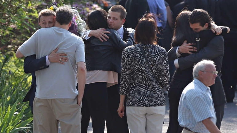 Family and friends console one another outside of the wake...