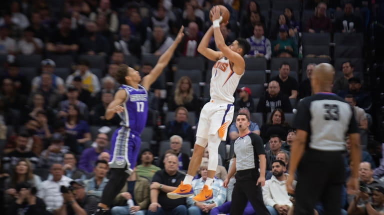 Phoenix Suns guard Devin Booker (1) shoots over Sacramento Kings...