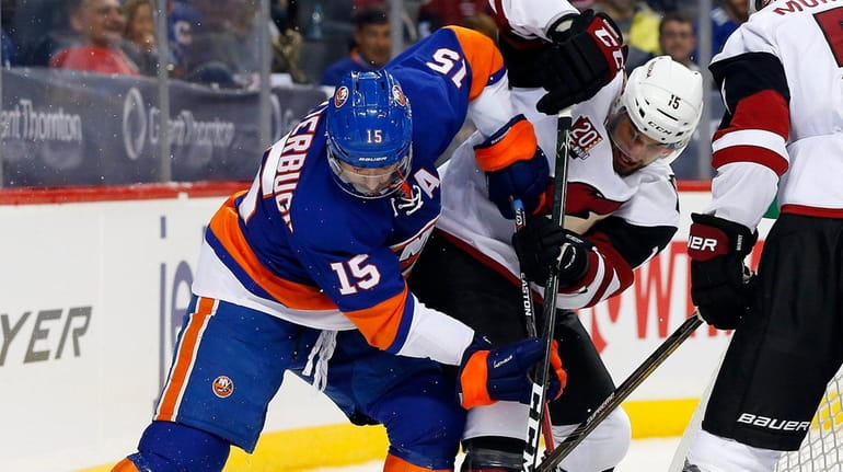 Cal Clutterbuck #15 of the New York Islanders battles for...