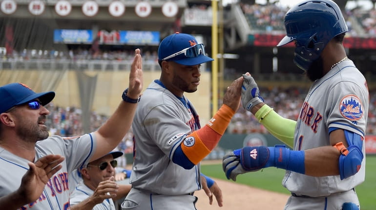 Mets manager Mickey Callaway and second baseman Robinson Cano congratulate...
