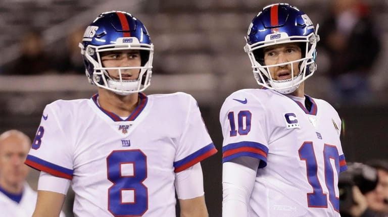 Giants quarterbacks Daniel Jones, left, and quarterback Eli Manning warm up before...