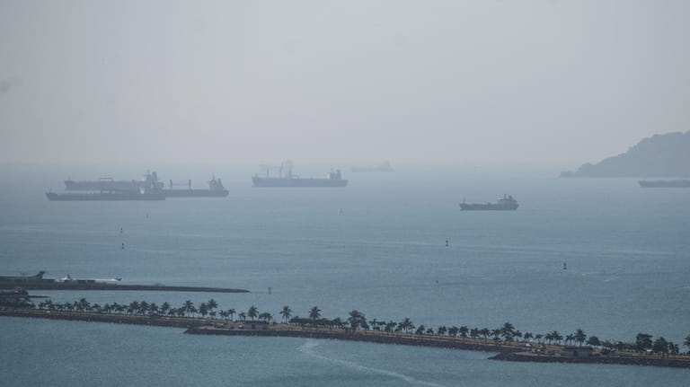 Cargo ships wait in Panama Bay for transit through the...