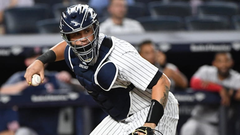 New York Yankees catcher Gary Sanchez looks to throw the...