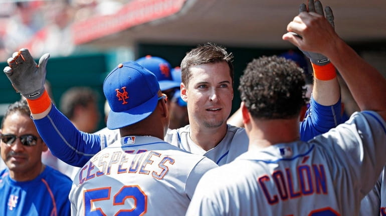 Kelly Johnson of the Mets celebrates with teammates in the...