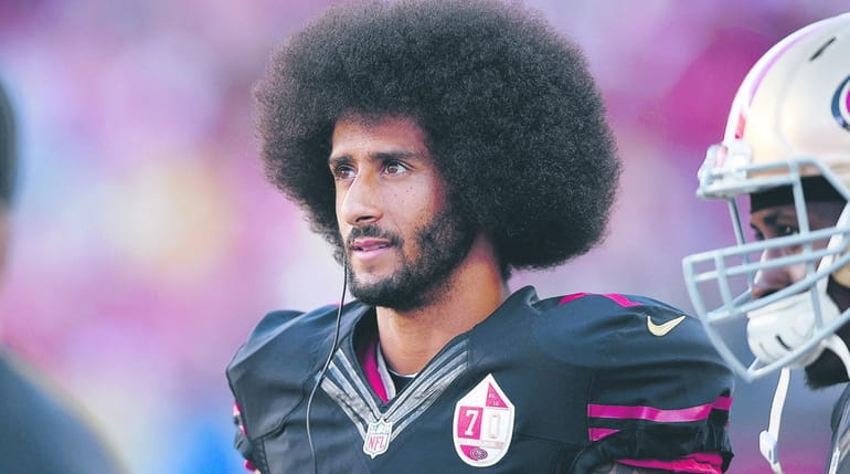 Colin Kaepernick of the San Francisco 49ers stands on the...