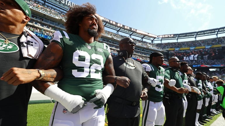 Leonard Williams of the New York Jets stands in unison...