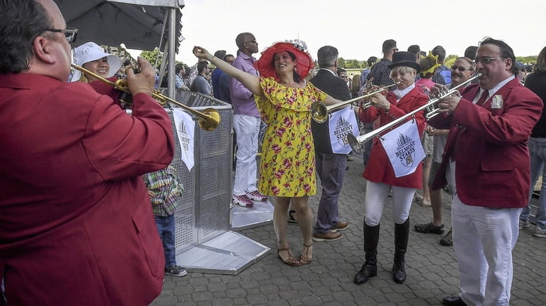 A woman dances to the buglers at Belmont Park in...