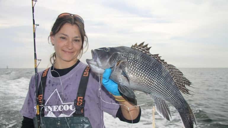 First mate Deena Lippman shows off a black sea bass...